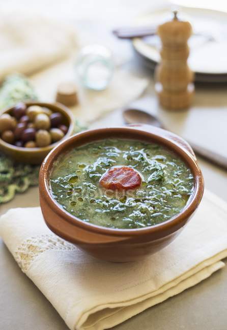 Caldo verde - Kartoffel-Grünkohl-Suppe mit Chorizo in Schüssel über Handtuch — Stockfoto