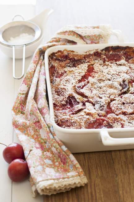 Closeup view of clafoutis with plums in a baking dish — Stock Photo