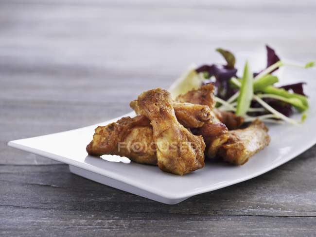 Chicken wings with mixed leaf salad — Stock Photo