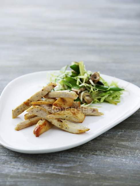 Strisce di pollo con insalata mista di foglie — Foto stock