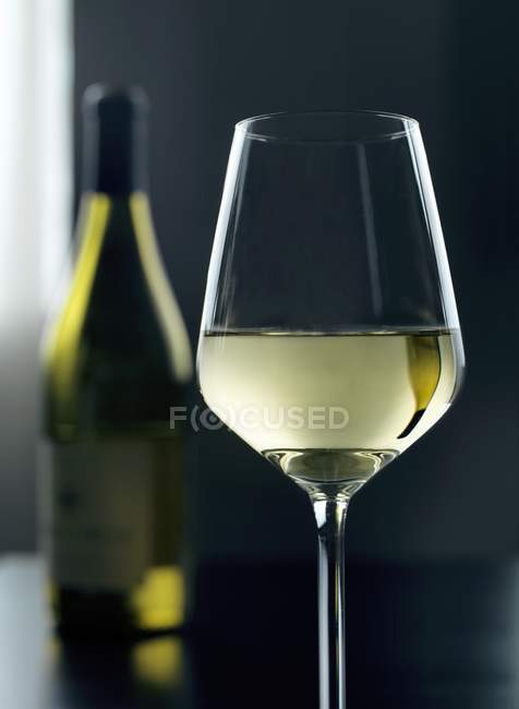 Glass and bottle of white wine — Stock Photo