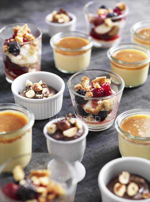 Closeup view of chocolate cream, Creme caramel and vanilla cream with berries and biscuit crumbs — Stock Photo
