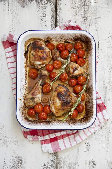 Жареная курица с розмарином и помидорами — стоковое фото