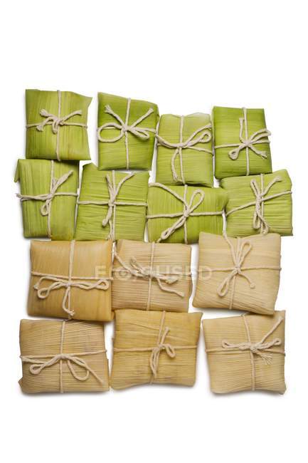Draufsicht auf gedämpfte Tamales-Pakete auf weißem Hintergrund — Stockfoto