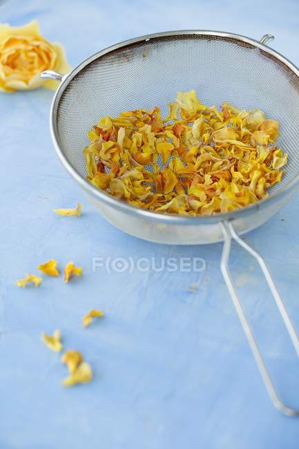 Nahaufnahme getrockneter gelber Rosenblätter in einem Sieb — Stockfoto