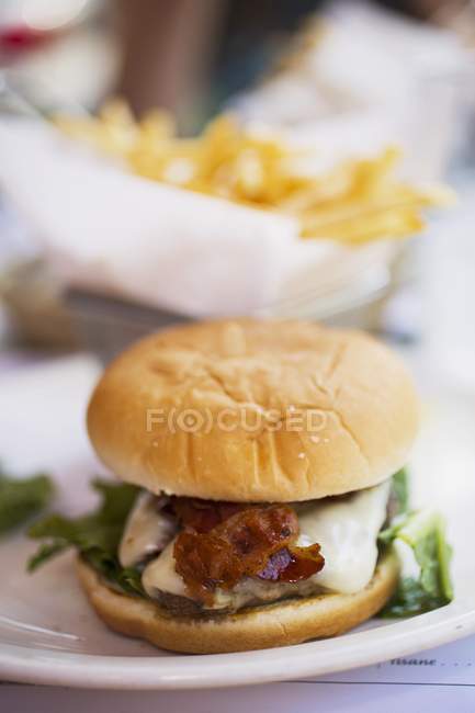 Cheeseburger con pancetta e patatine fritte — Foto stock