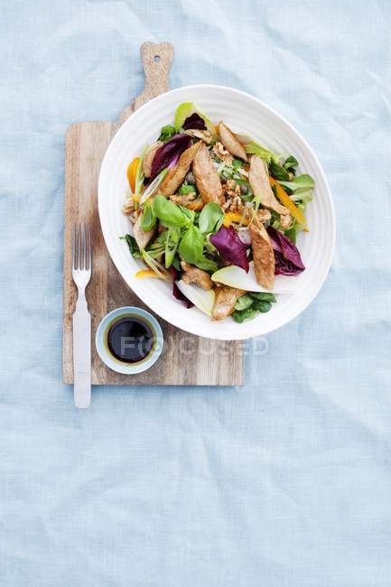 Nahaufnahme von Hühnersalat mit Nüssen und Basilikum in Schüssel — Stockfoto