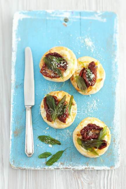 Puff pastry tartlets with dried tomatoes — Stock Photo