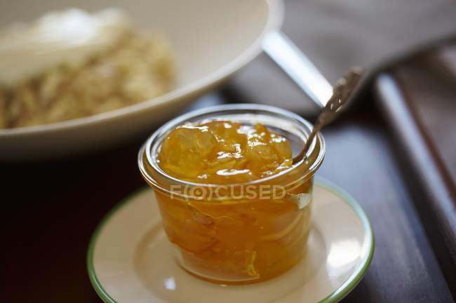 Glass with spoon of jelly — Stock Photo
