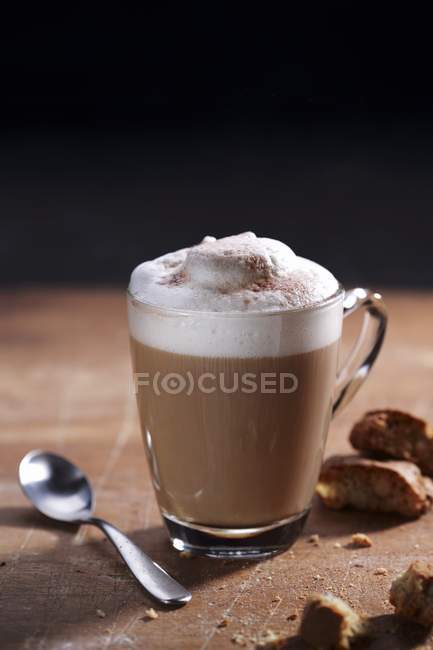 Cappuccino with milk foam and spoon — Stock Photo