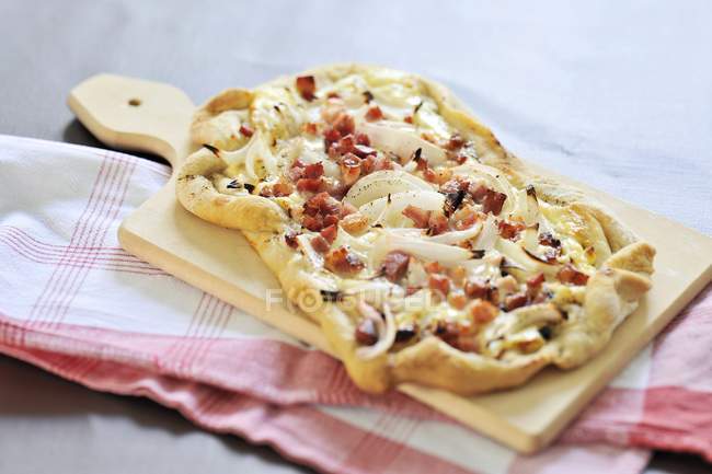 Close up of Tarte flambe topped with bacon and onions — Stock Photo