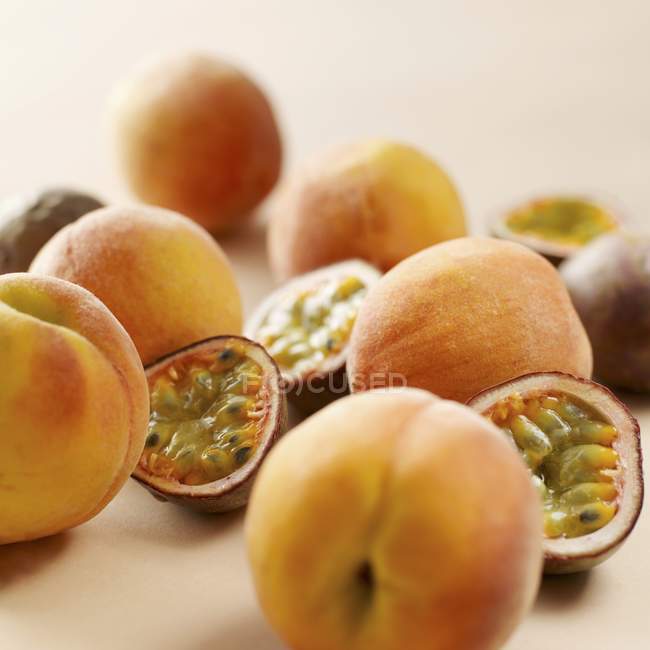 Red passion fruits and peaches — Stock Photo
