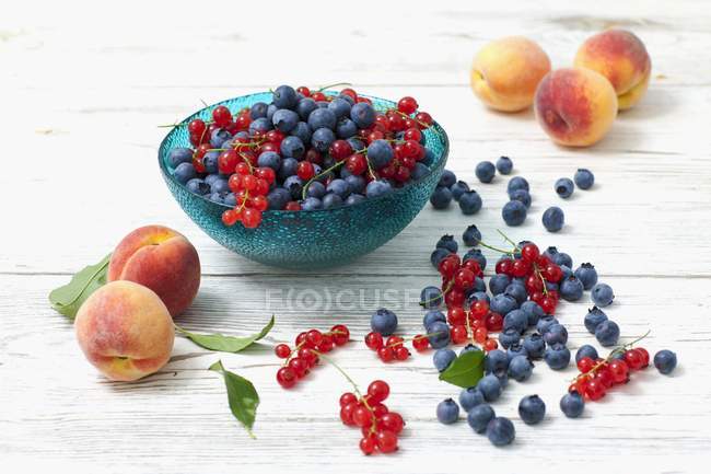 Blaubeeren mit roten Johannisbeeren und Pfirsichen — Stockfoto