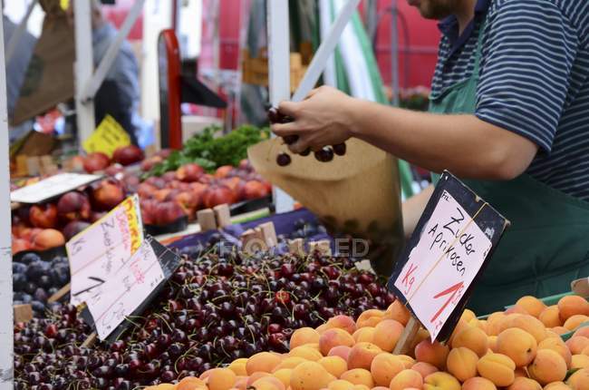Fruit seller filling bag — Stock Photo
