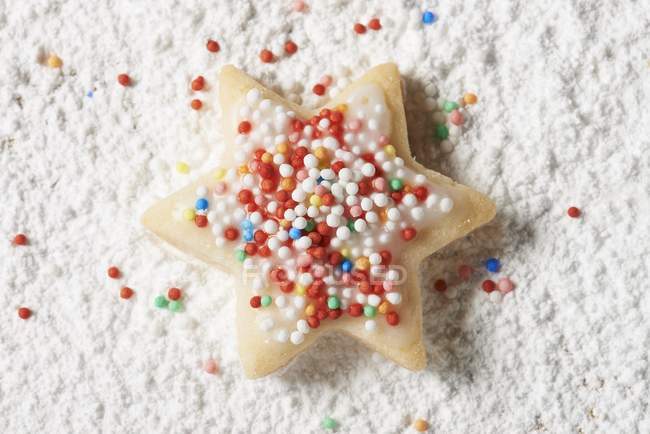 Star-shaped biscuit with colourful sprinkles — Stock Photo
