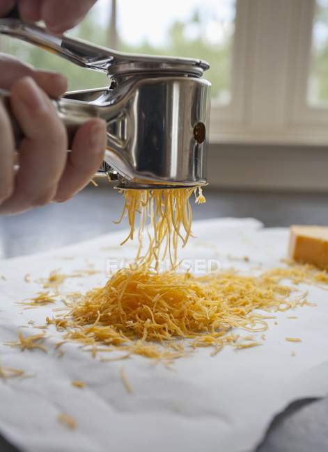 Grating Cheddar cheese — Stock Photo