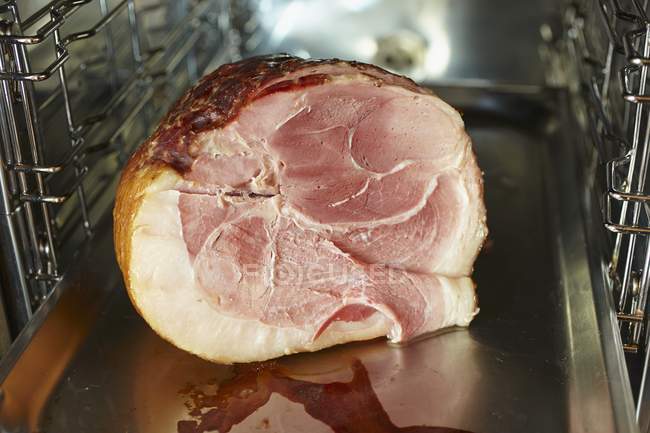 Fresh glazed ham in oven — Stock Photo