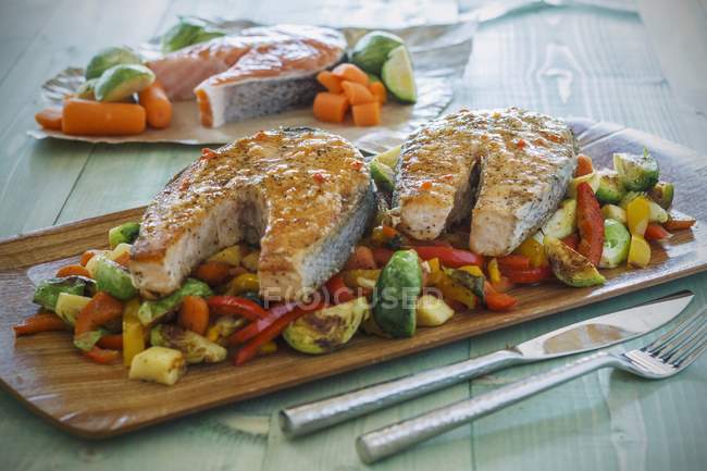 Roasted salmon on a bed of mixed vegetables — Stock Photo