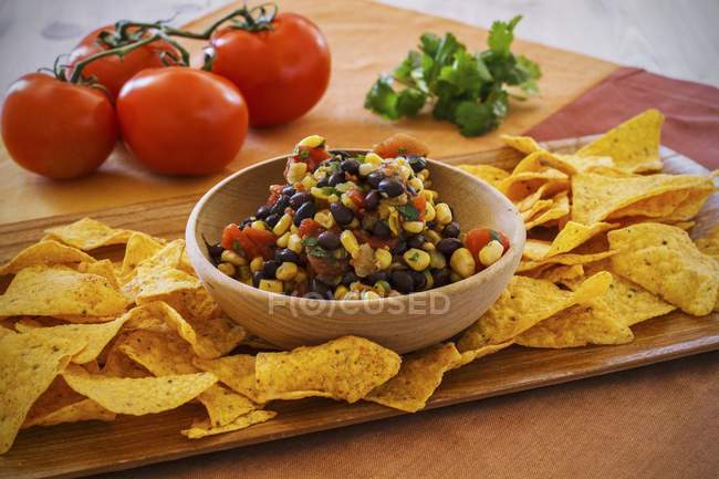 Mais-Salsa mit schwarzen Bohnen und Tortilla-Chips auf Holztisch — Stockfoto