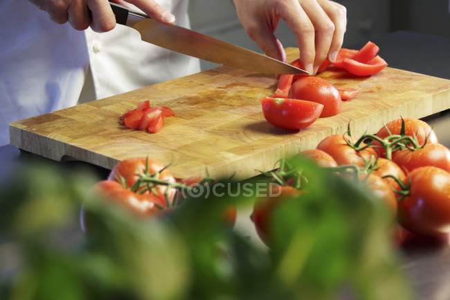Руки рубають свіжі помідори — стокове фото