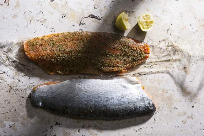 Маринований лосось з половинками лимона — стокове фото