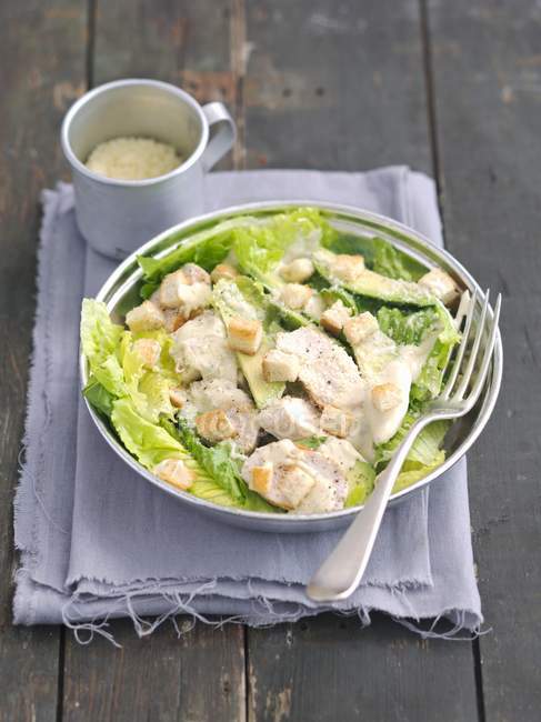 Caesar-Salat mit Avocado, gegrilltem Huhn und Croutons auf weißem Teller mit Gabel — Stockfoto
