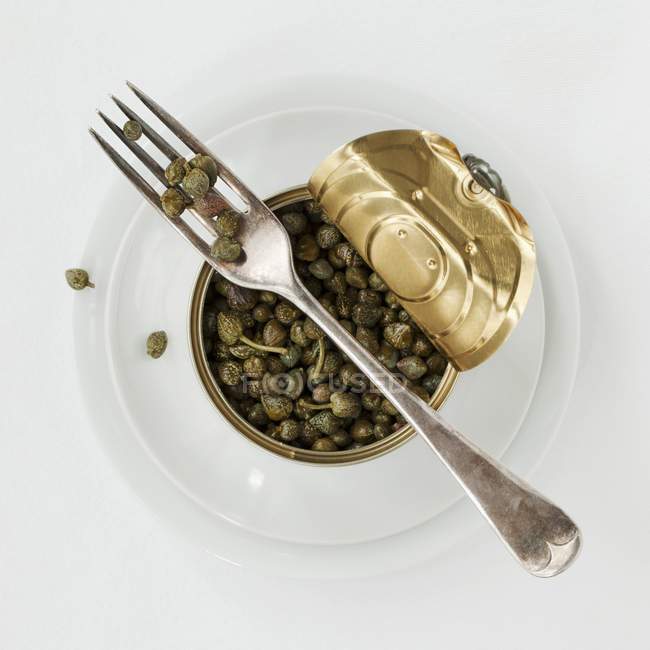 Tin of capers with fork — Stock Photo