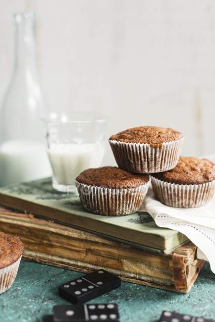 Muffins and milk on stack of book — Stock Photo