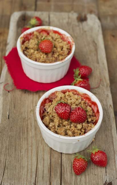 Closeup view of strawberry crumble with berries in bowls — Stock Photo