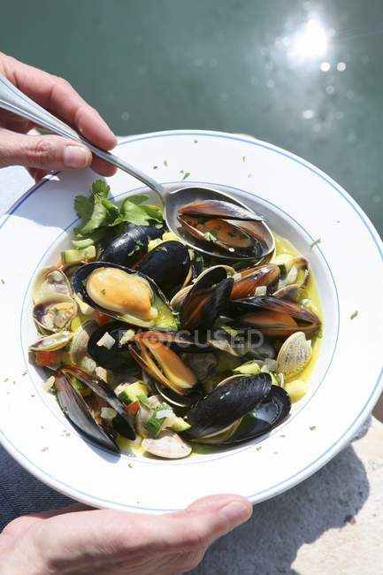 Man eating mussel  soup — Stock Photo