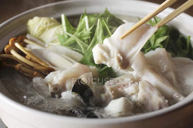 Pentola calda giapponese con baccalà, verdure e funghi su piatto bianco — Foto stock