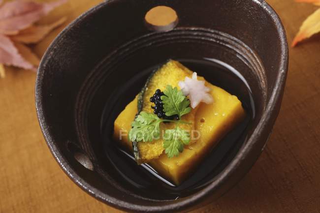 Tofu à la citrouille dans un bol noir sur la table — Photo de stock
