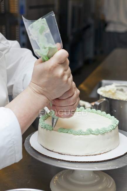 Chef glaçant un gâteau — Photo de stock