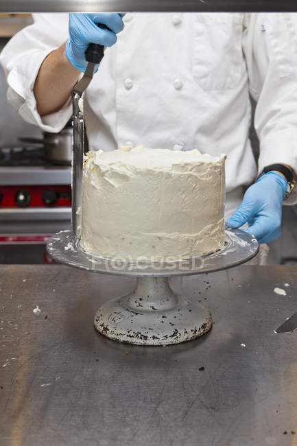 Confectioner decorating a cake — Stock Photo