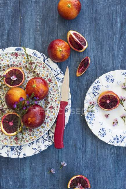 Blood oranges on decorative plates — Stock Photo