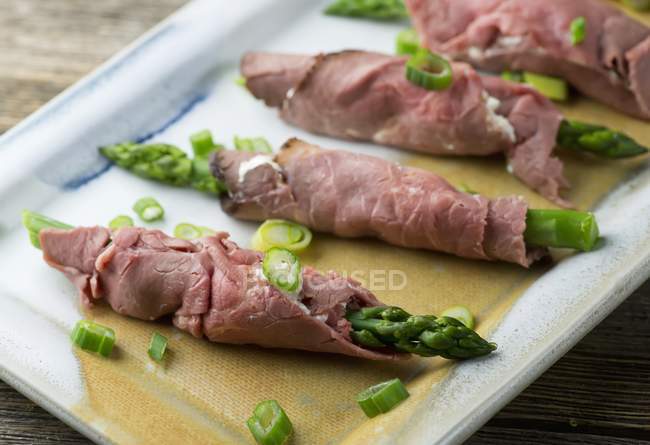 Espargos verdes embrulhados em carne crua — Fotografia de Stock