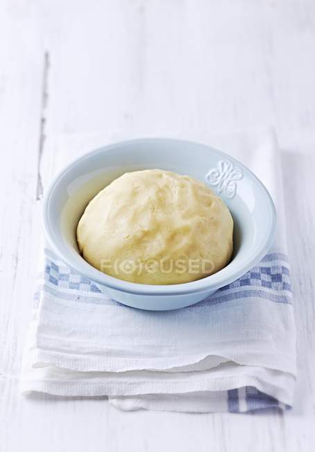 Closeup view of shortcrust pastry ball in bowl on towel — Stock Photo