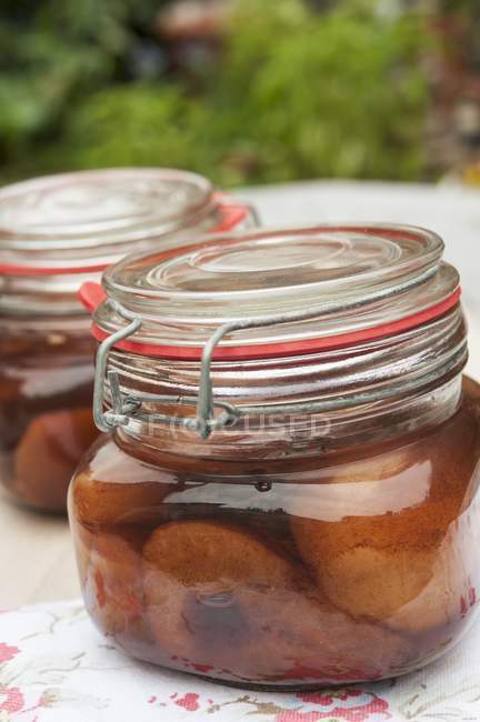 Closeup view of pears in cherries in preserving jars — Stock Photo