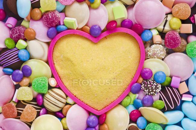 Vista close-up de açúcar amarelo no molde de cozimento cercado por doces — Fotografia de Stock