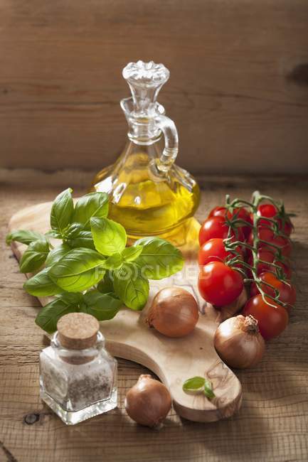 Аранжування цибулі, помідорів, спецій, базиліка та оливкової олії — стокове фото