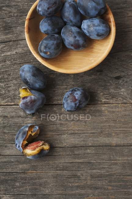 Fresh plums in a wooden bowl — Stock Photo