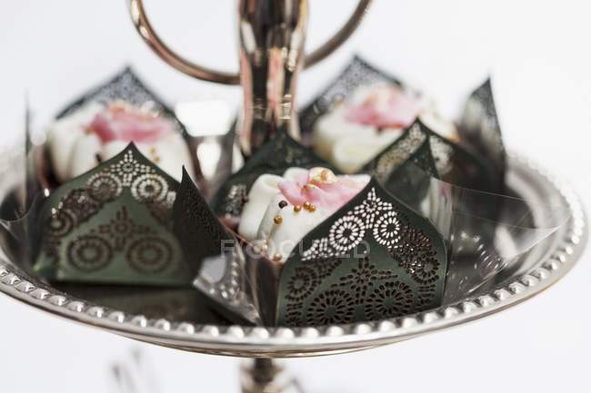 Vista close-up de confeitaria de chocolate em elegantes caixas de papel decoradas com rosas e pérolas de açúcar dourado — Fotografia de Stock