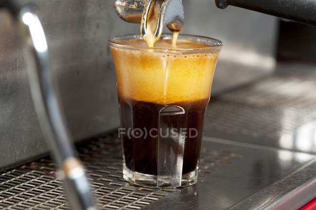Espresso derramando da máquina em vidro — Fotografia de Stock