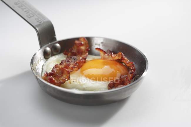 Fried egg with bacon in frying pan — Stock Photo