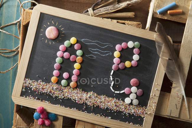 Top view of bonbon man with a kite on a chalkboard — Stock Photo