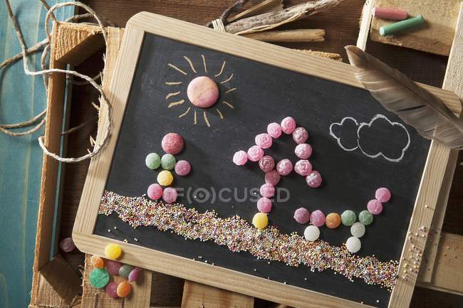 Top view of beach scene with a parasol, lounger and a man on a chalkboard — Stock Photo