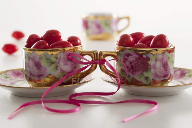 Closeup view of pink sugared almonds in cups tied together — Stock Photo