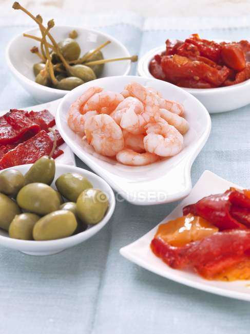 Vari tipi di antipasti (gamberi, olive, peperoni e capperi giganti ) — Foto stock