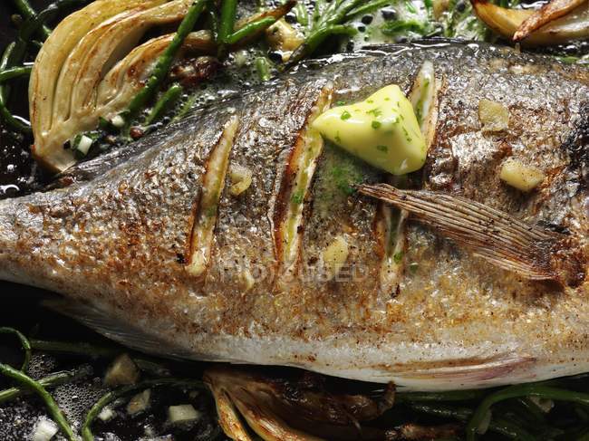 Fried sea bass with herb butter — Stock Photo