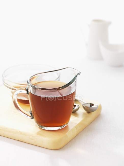 Closeup view of clear stock in a glass jug — Stock Photo